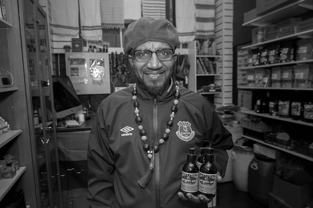 The owner of Royal Maroon Herbs holding bottles of argan oil