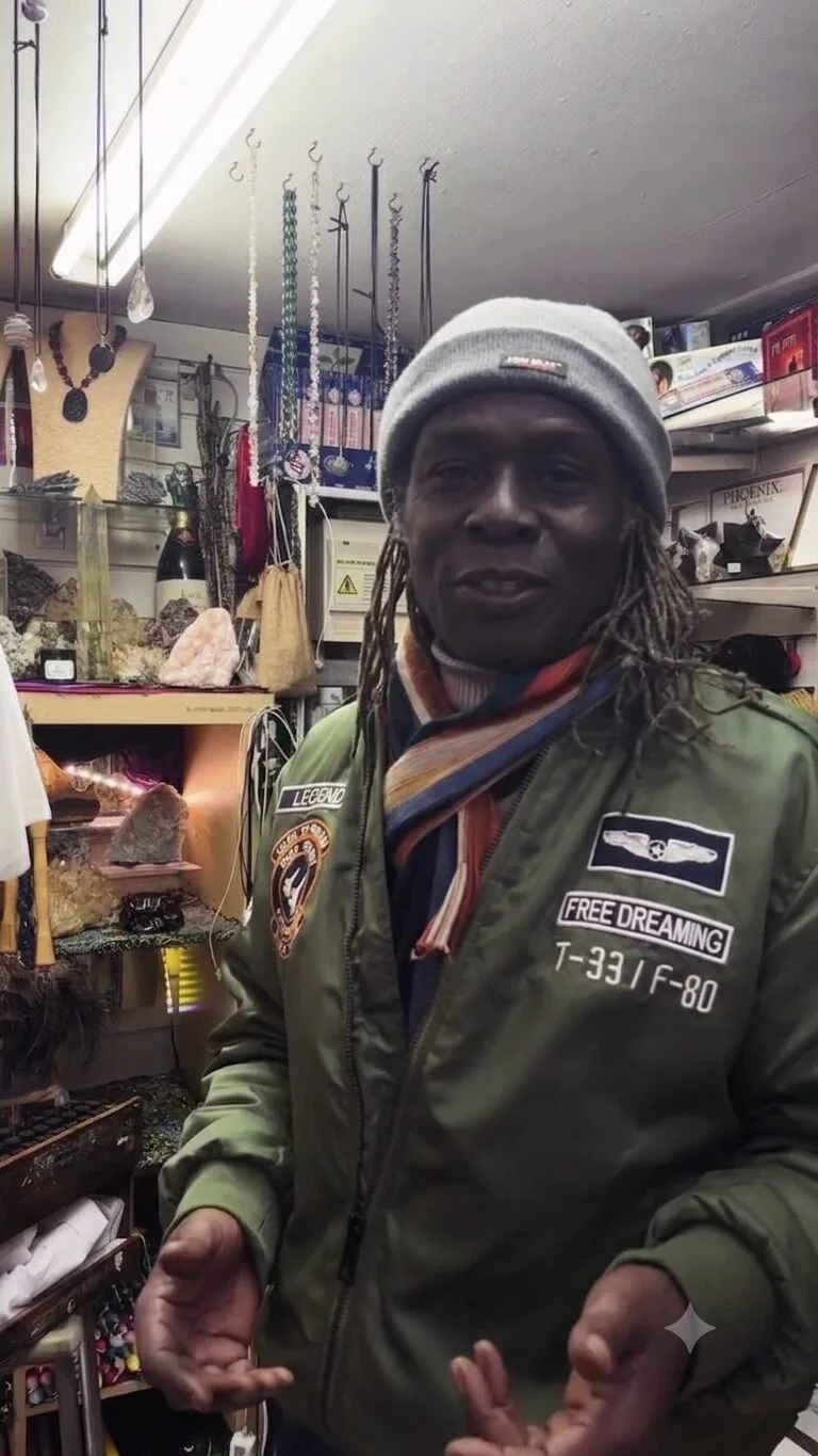 The owner of Peckham Crystals & Fossils surrounded by minerals and gems